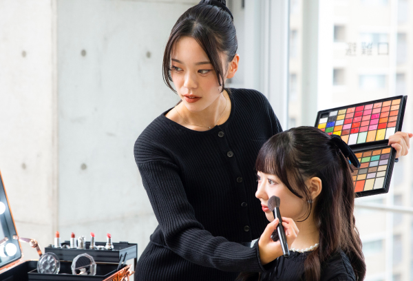 メイクを行う学生