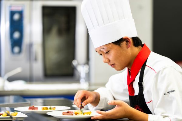 ケーキにトッピングをする学生