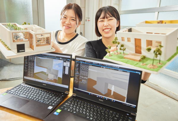 建築模型を持つ二人の学生