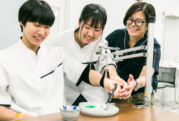 医療器具を体験する学生と講師