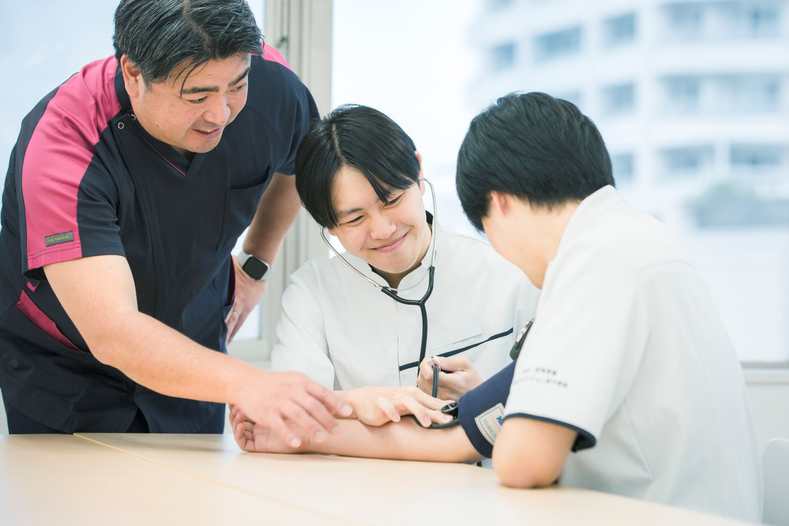 医療器具を体験する学生と講師