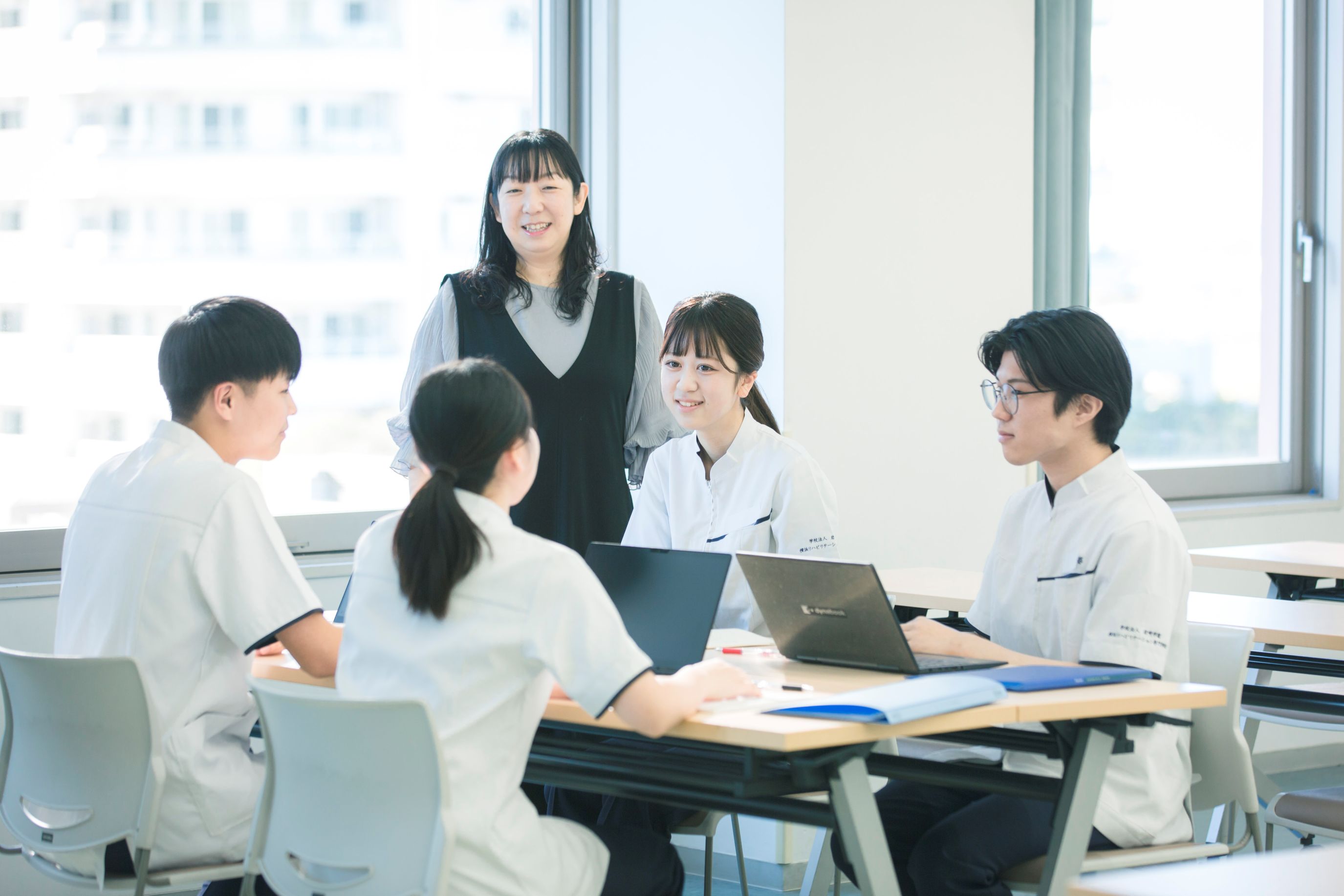 実習中の学生と説明をする講師